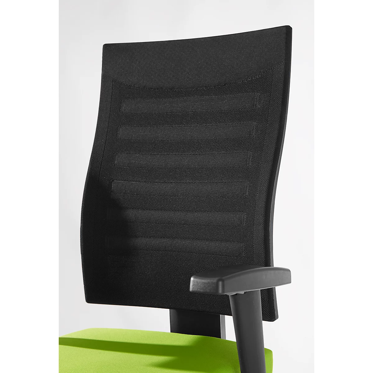 Close-up of the black back of an office chair with vertical bars. Below, a green seat and black armrest.