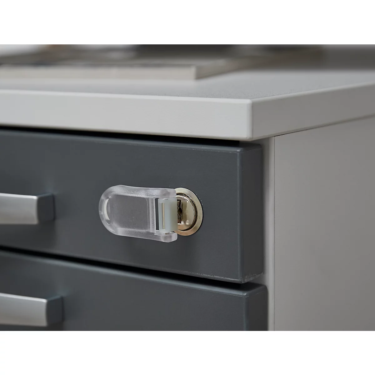Close-up of a gray drawer with a key protected by a clear plastic protector.