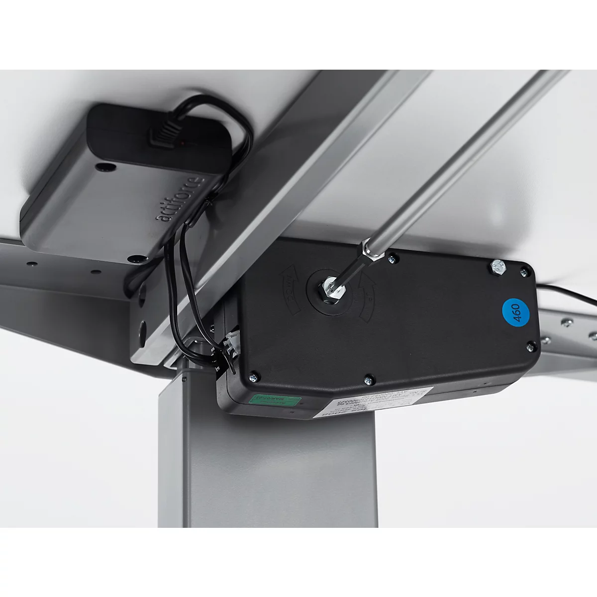 Detailansicht der Unterseite eines höhenverstellbaren Schreibtisches, Motor, Kabel und Steuerung.