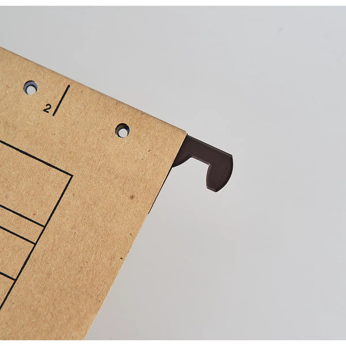 Close-up of a brown file card label with a metallic hook against a light background.