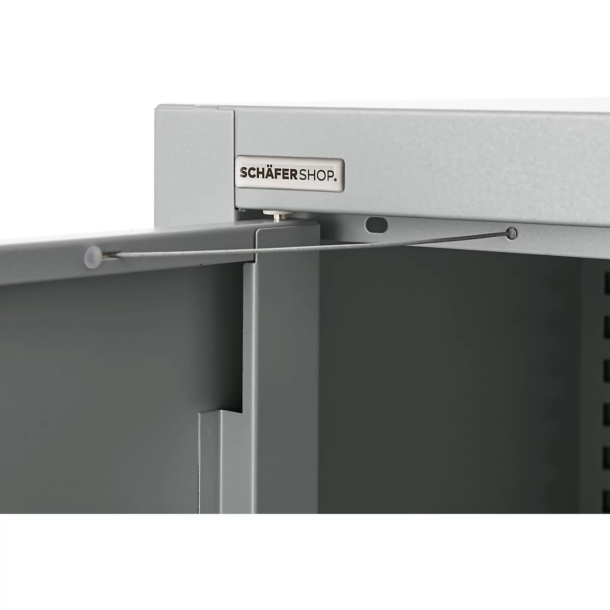 Detailed view of a gray metal cabinet with the door partially open. The top reads "SCHÄFERSHOP".