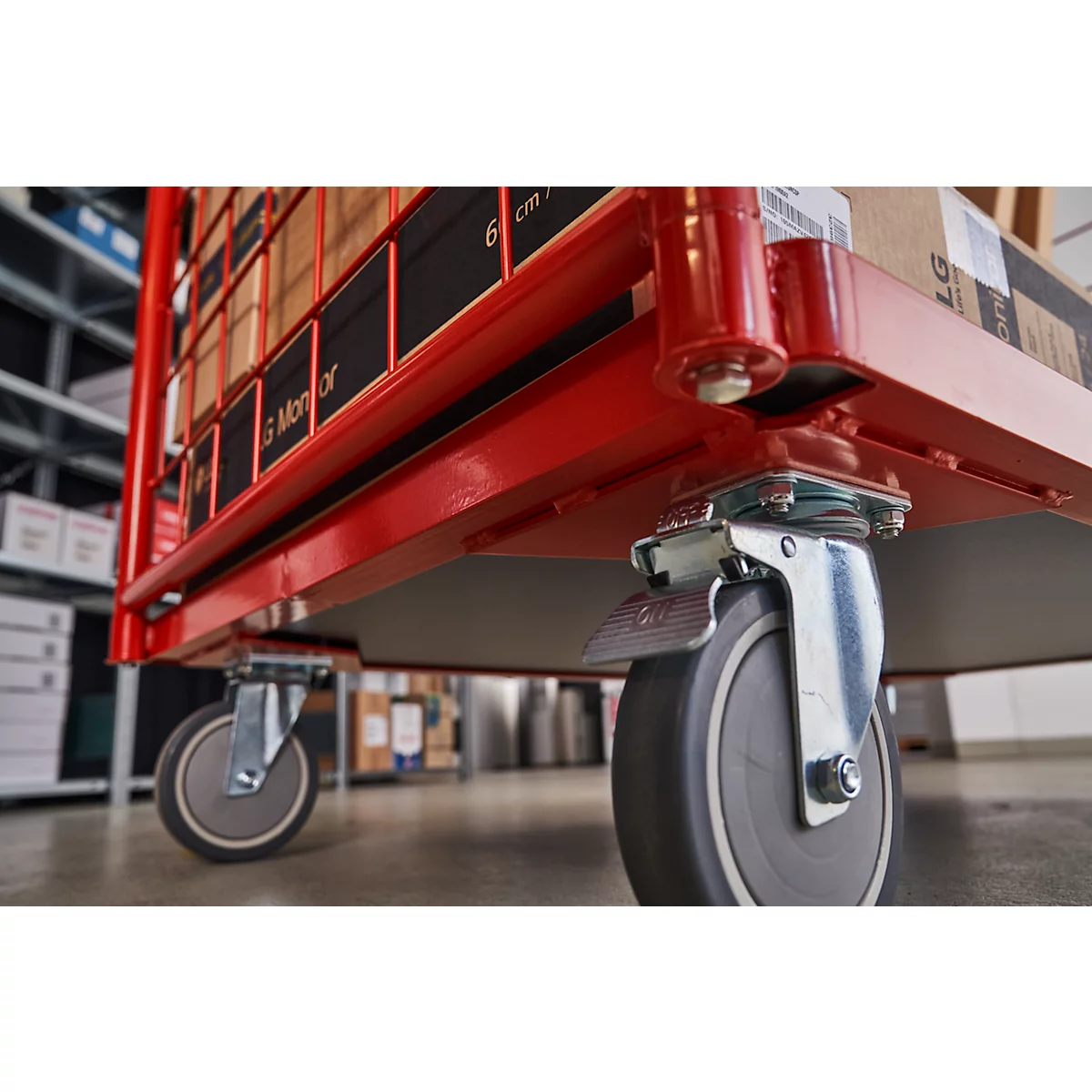 Close-up of a red transport cart with four wheels and boxes.