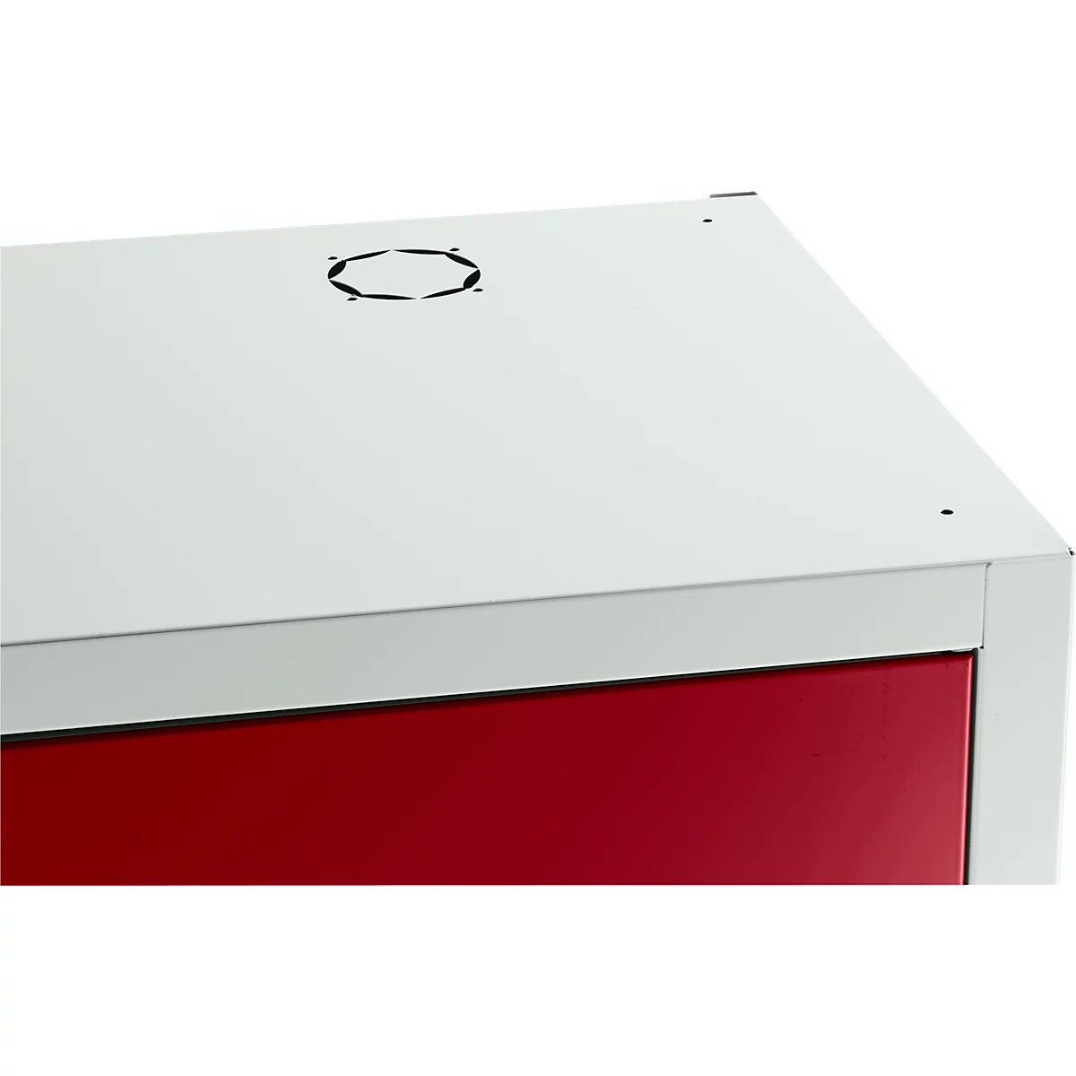 Ecke eines weißen Schranks mit roter Tür und Lüftungsloch. Minimalistisches Design.