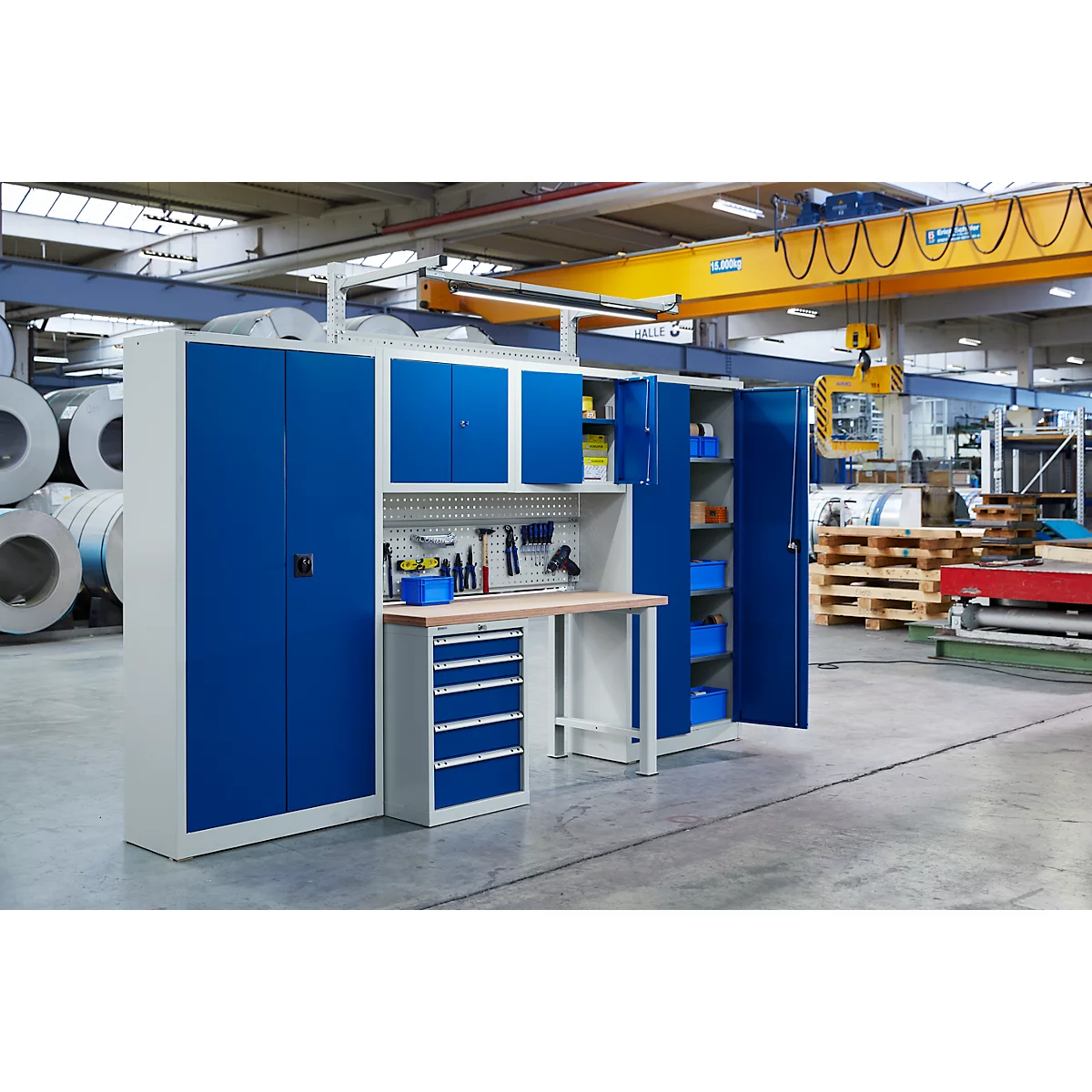 Workbench and cabinet wall in a workshop. Tools, cabinets and drawers in blue and beige.