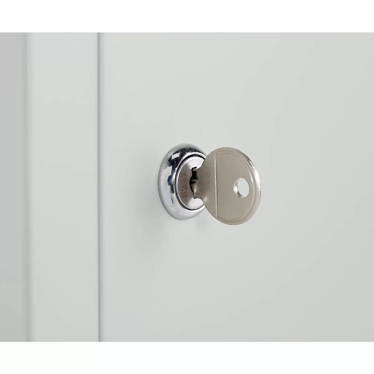 Close-up of a key in a keyhole. The silver key is inserted into the lock.