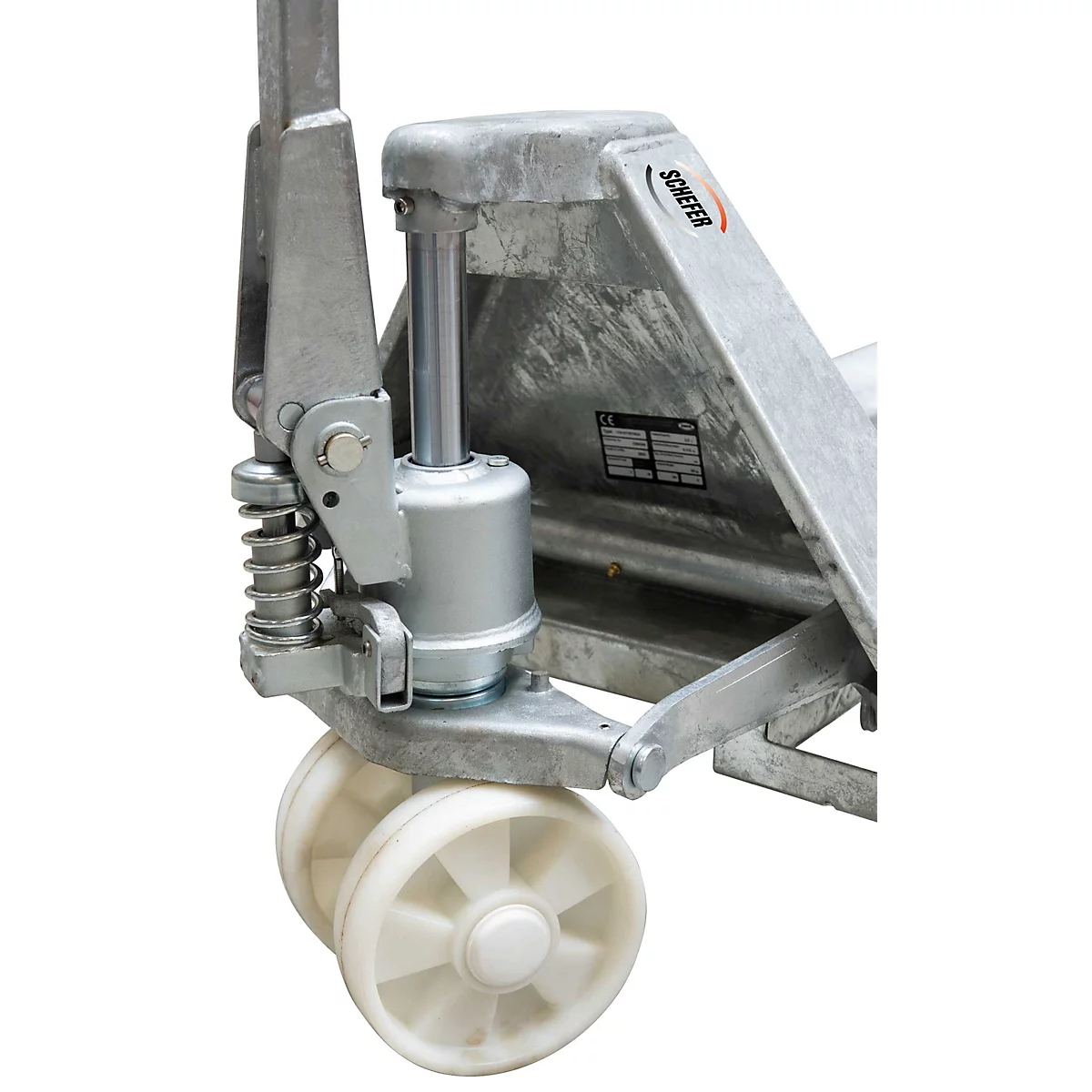 Nahaufnahme des Hydraulikzylinders und der weißen Kunststoffrollen eines verzinkten Hubwagens von Schefer.
