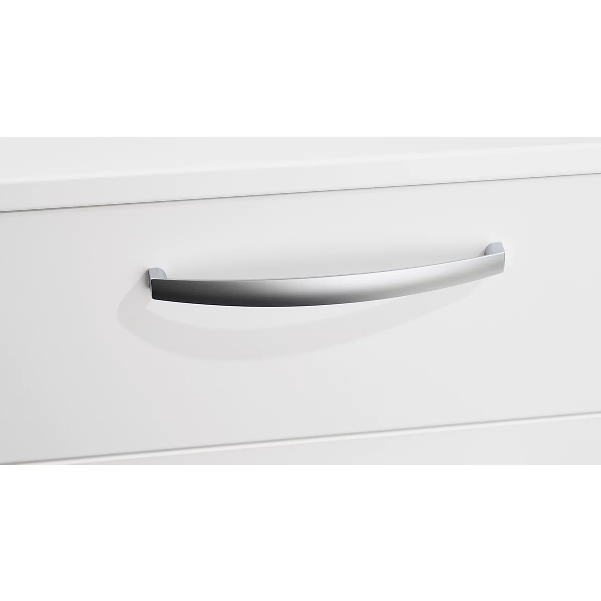Nahaufnahme einer weißen Schublade mit einem gebogenen, silbernen Griff. Die glatte Oberfläche kontrastiert mit der Form des Griffs.
