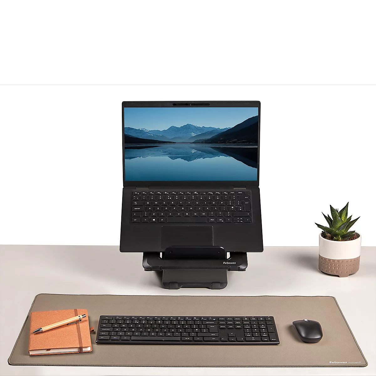 Mehrere gerollte Mousepads in verschiedenen Grau- und Schwarztönen, mit dem Markenlogo Fellowes Microban.