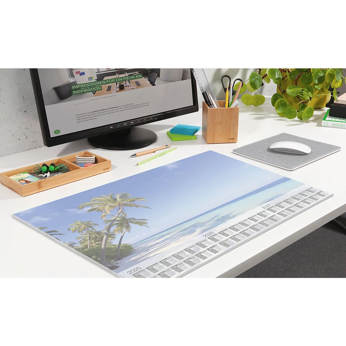 Schreibtisch mit Strandlandschaft, Kalender, Computer, Maus, Stifthalter, Pflanze.