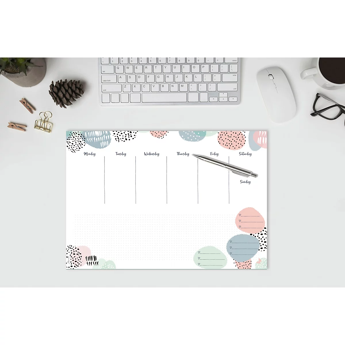 Wochenplaner mit abstrakten bunten Formen, Stift, Tastatur und Maus auf weissem Schreibtisch.