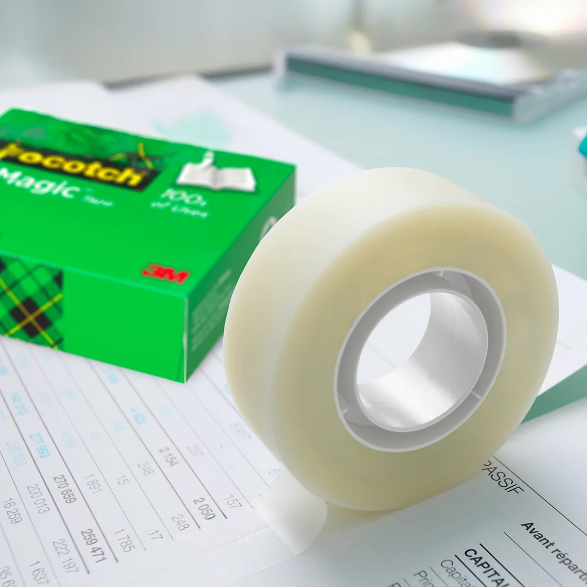 Rolle Scotch Magic Klebeband auf Dokumenten. Auf gelbem Banner steht: Unsichtbar bei der Anwendung.