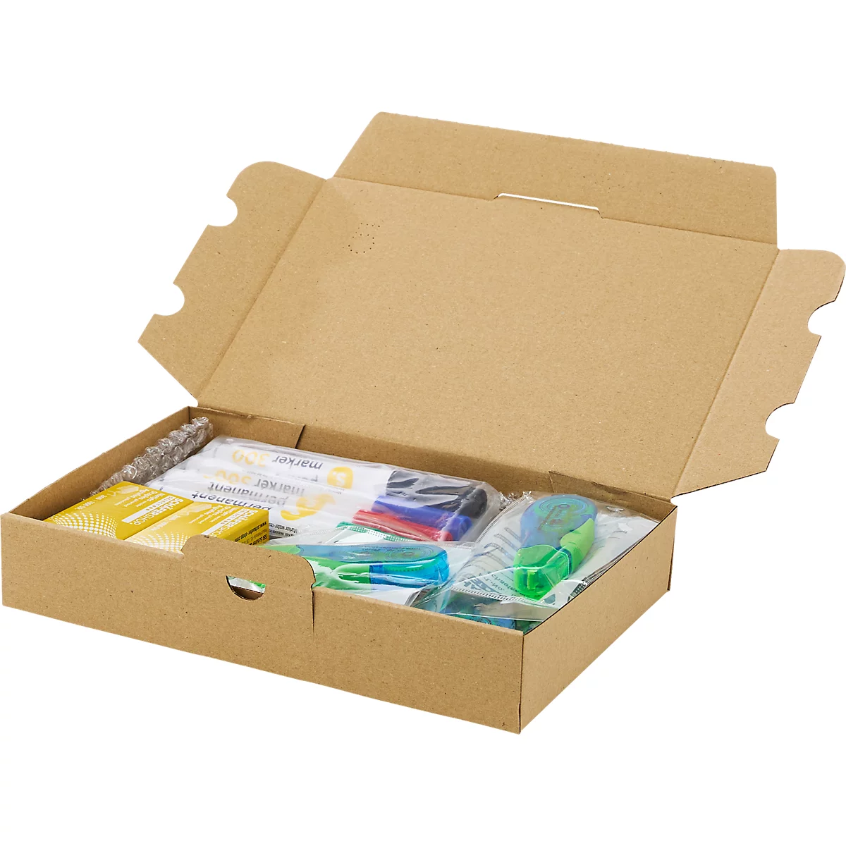 Offener brauner Pappkarton mit Schreibwaren, darunter Stifte und Blöcke, in Plastik verpackt.