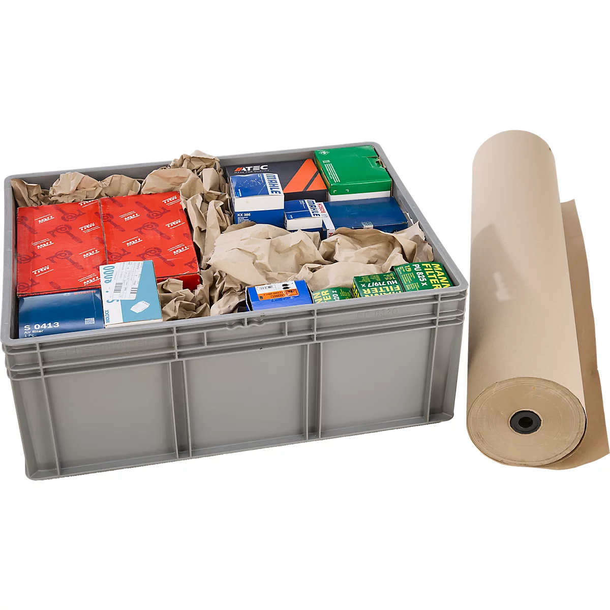 Graue Kunststoffkiste mit Ersatzteilen in Kartons und Füllpapier, daneben eine Rolle braunes Packpapier.