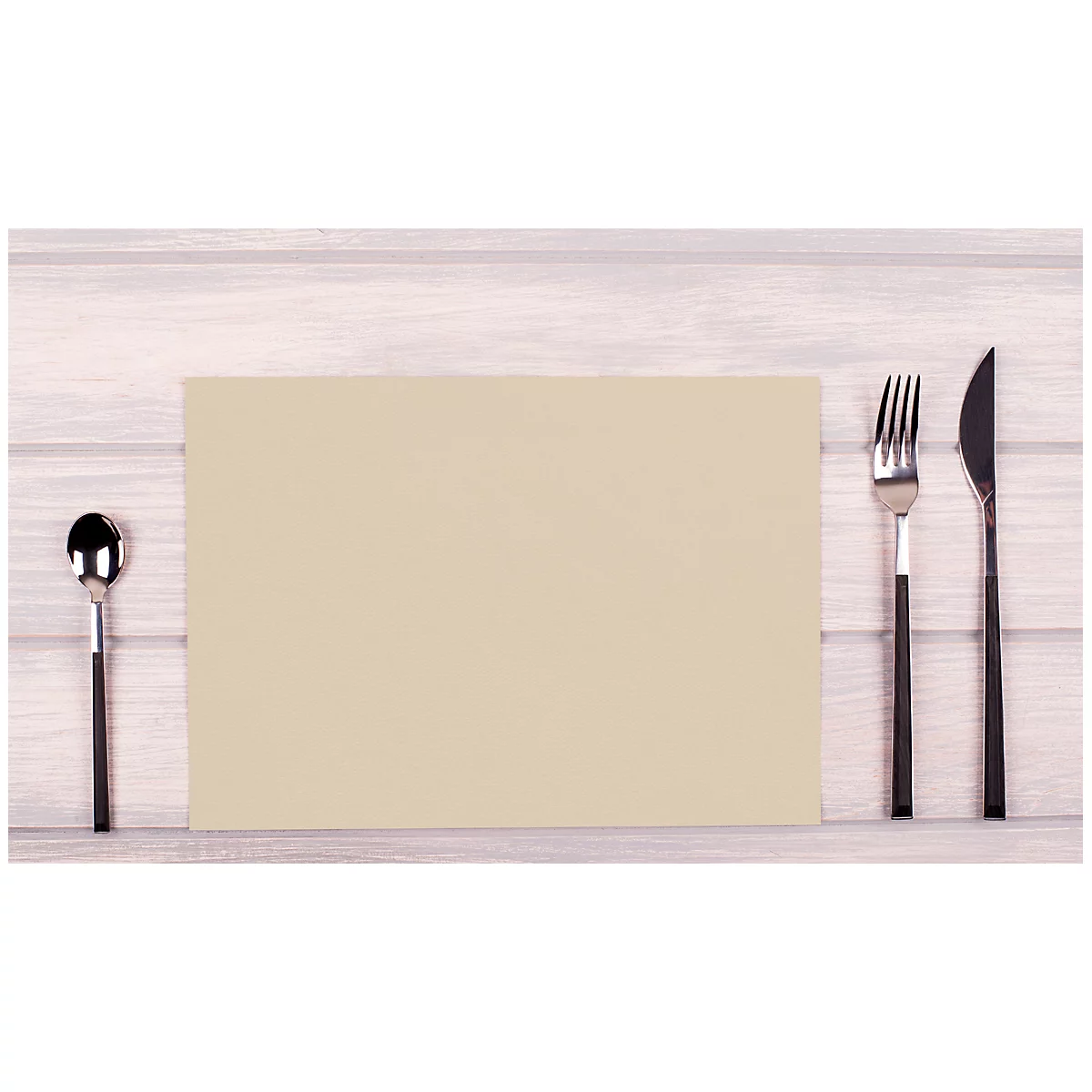 Sur une planche de bois : cuillère à gauche, nappe en papier au milieu, fourchette et couteau à droite.