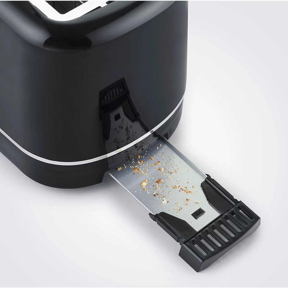 Close-up of a black toaster. The crumb tray is pulled out and filled with crumbs.