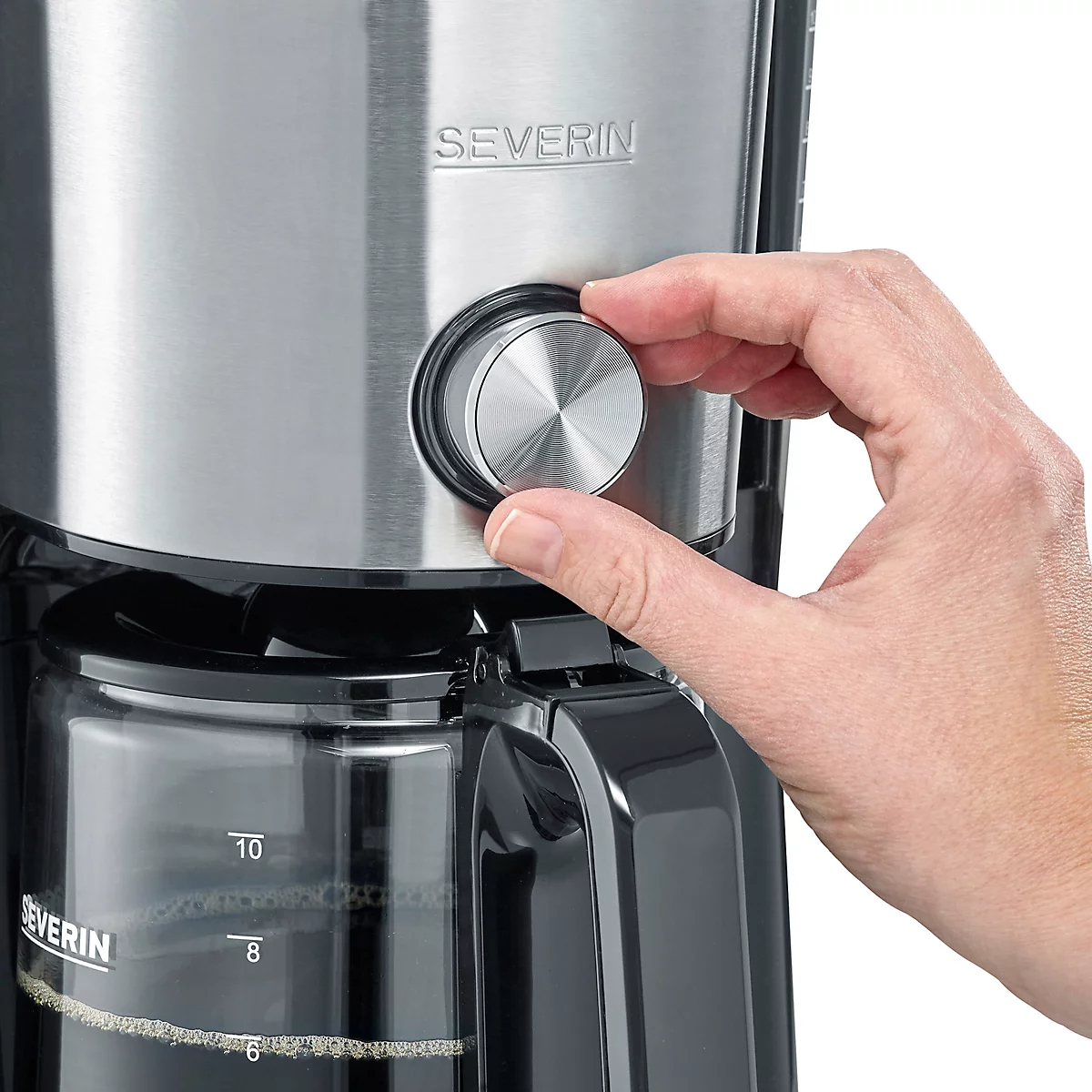 Gros plan sur une cafetière, une main tourne le bouton rotatif argenté à côté d'un récipient en verre avec un indicateur de niveau d'eau.