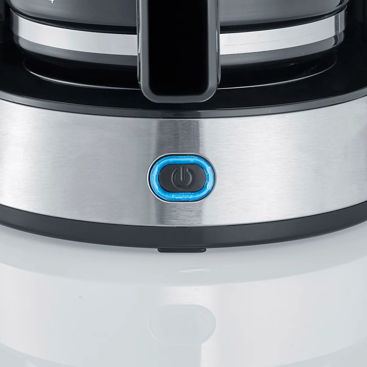 Gros plan d'une cafetière, bouton d'alimentation éclairé en bleu.