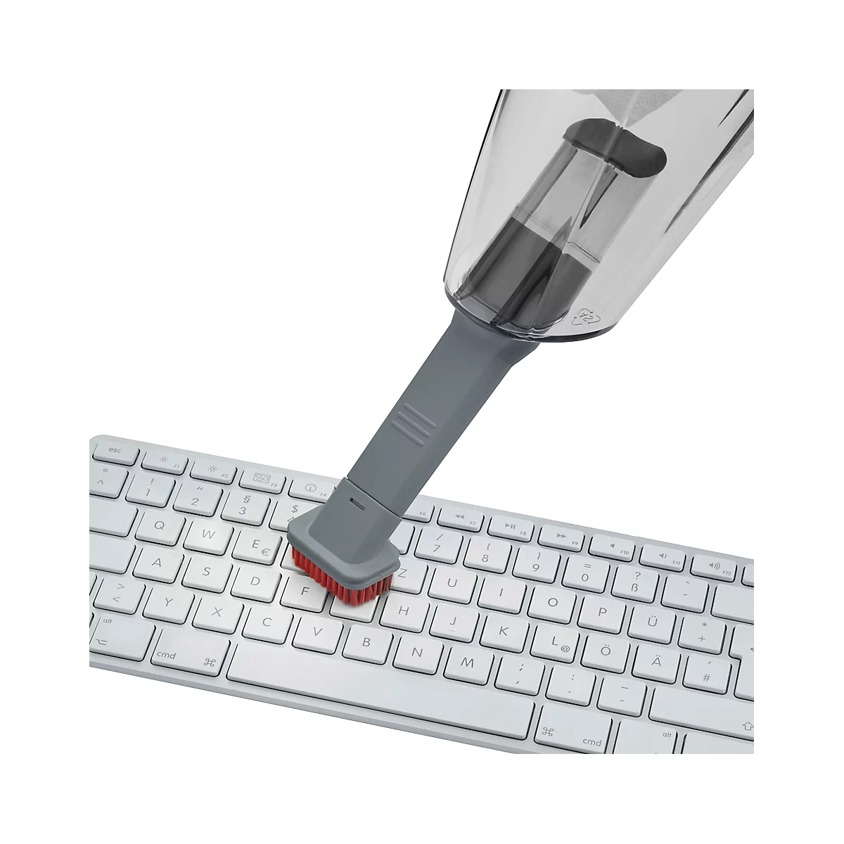 Close-up of a grey mini vacuum cleaner vacuuming a white keyboard. The bristles are red.