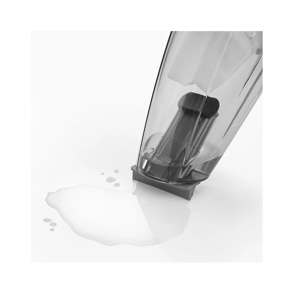 Part of a transparent blender pouring liquid onto a white surface.