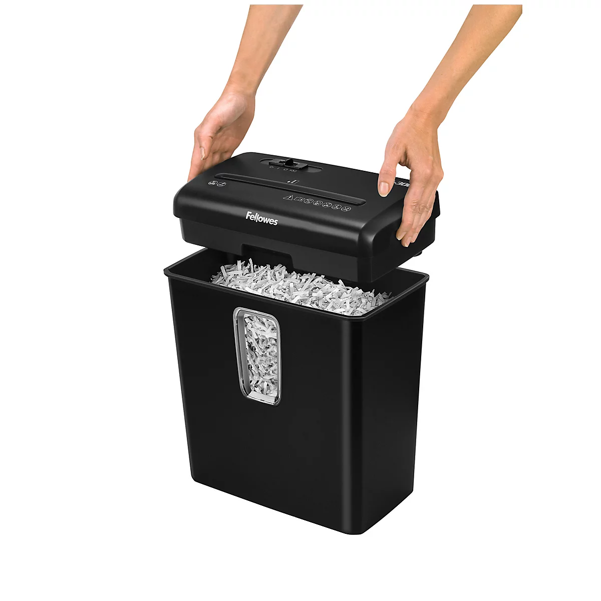 Shredder top being lifted by hands, filled with shredded paper. Black waste bin.