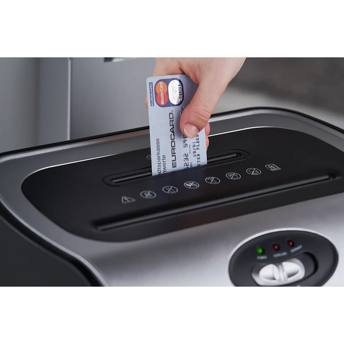 A hand is inserting a Eurocard into a shredder.