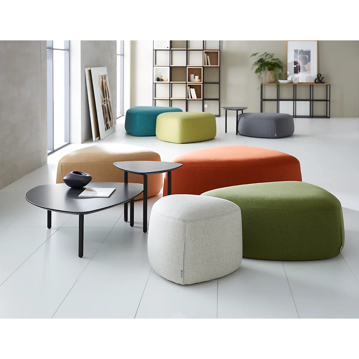 Various colorful seating and tables in a bright room. Some are round and others are square, in different colors.