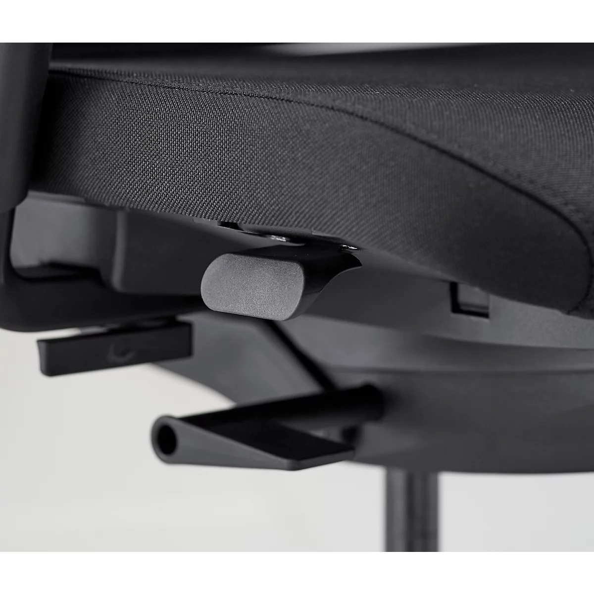 Détail d'une chaise de bureau. Leviers gris, cadre et assise noirs.