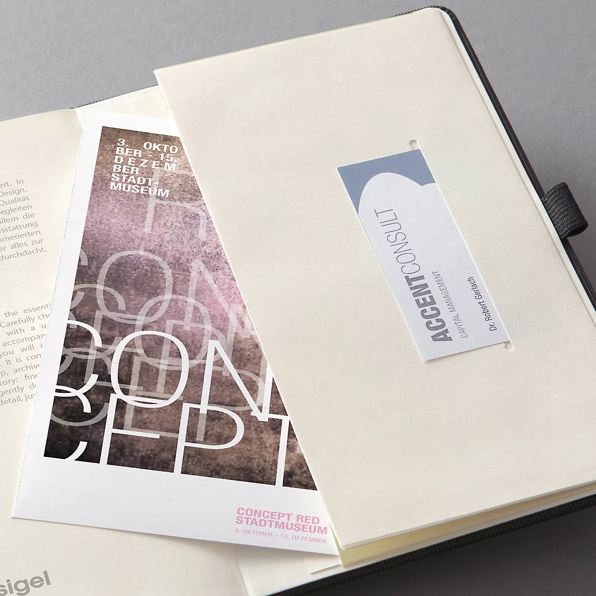 Carnet avec une carte imprimée "Concept Red Stadtmuseum" et un marque-page "Accent Consult".