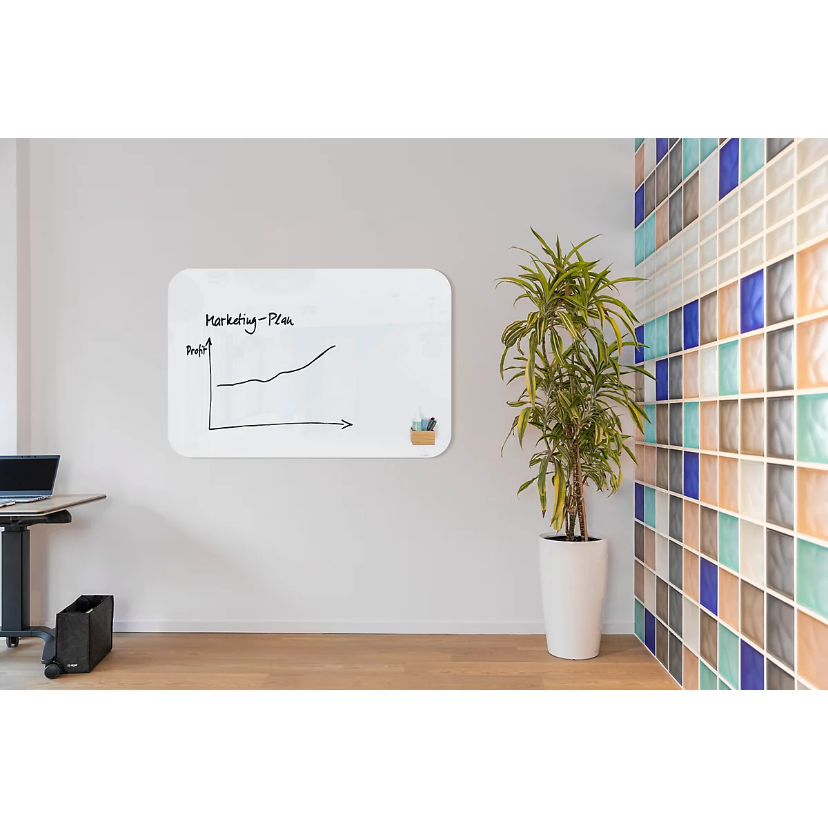 Weißes Whiteboard mit Diagramm an heller Wand. Rechts eine Topfpflanze, dahinter eine gemusterte Wand.