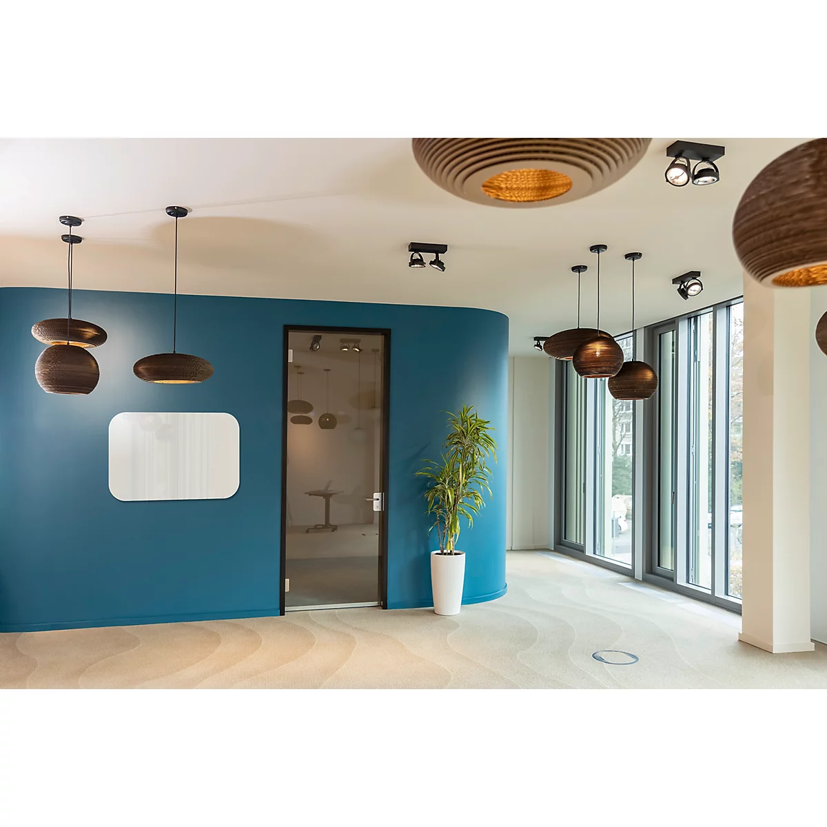 Moderne Inneneinrichtung, blaue Wand, Designer-Leuchten, helle Fenster, Pflanzen.