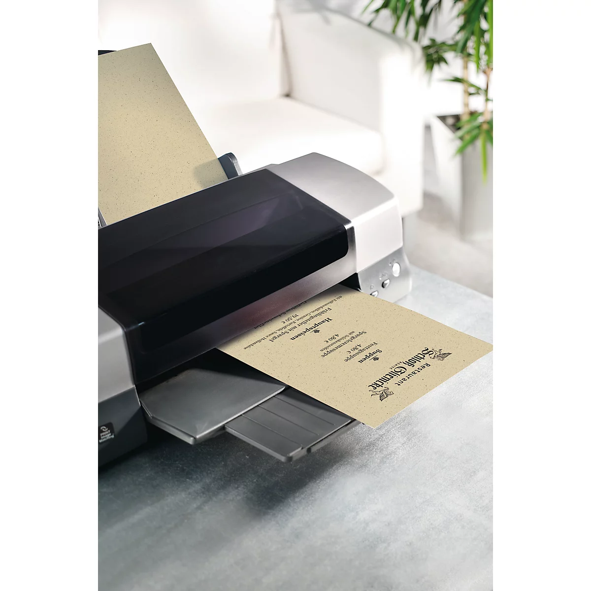 Een printer print een beige document, dat op de uitvoerlade ligt.