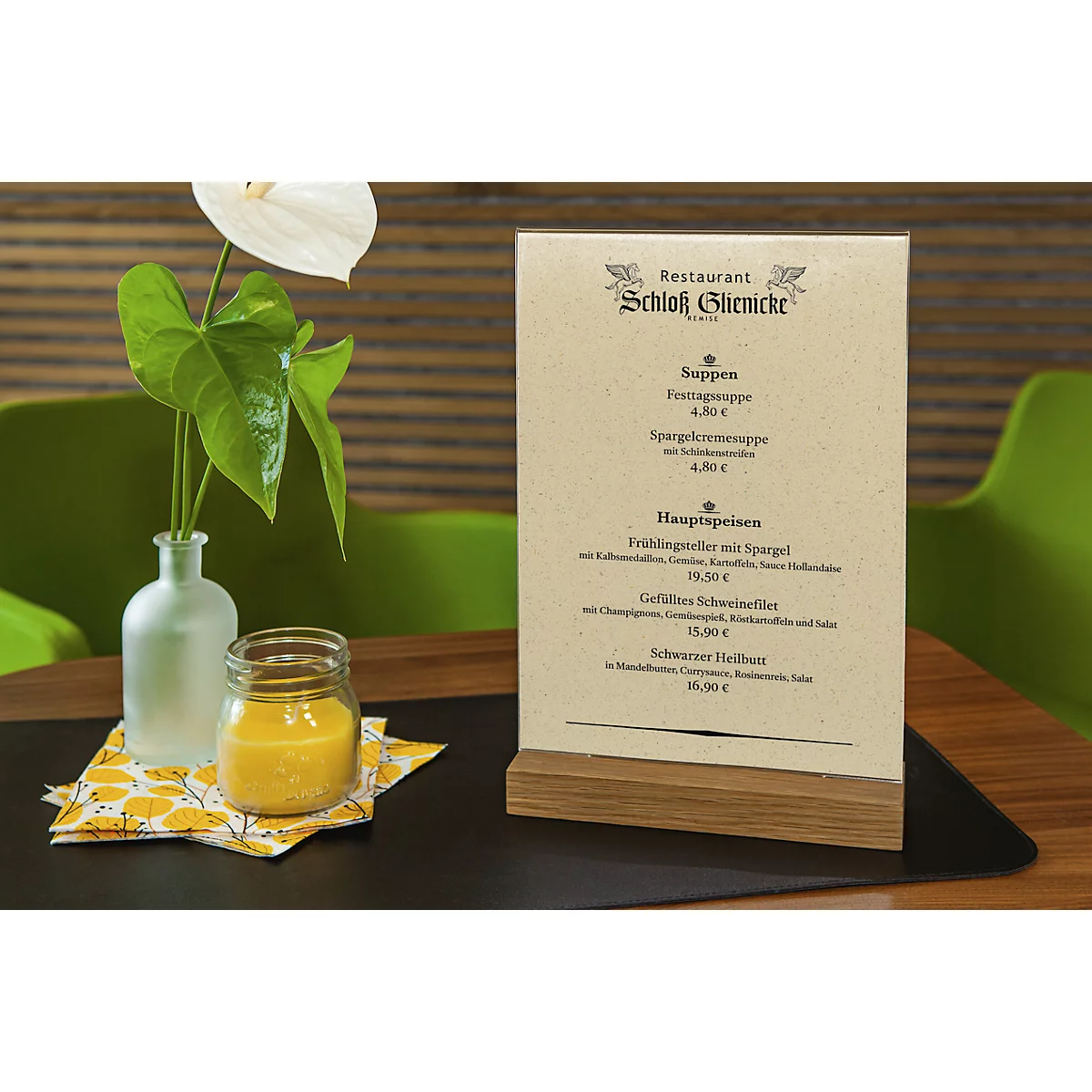 Tisch mit Menükarte vom Restaurant Schloss Glienicke, Vase mit Blume, Glas mit Getränk.