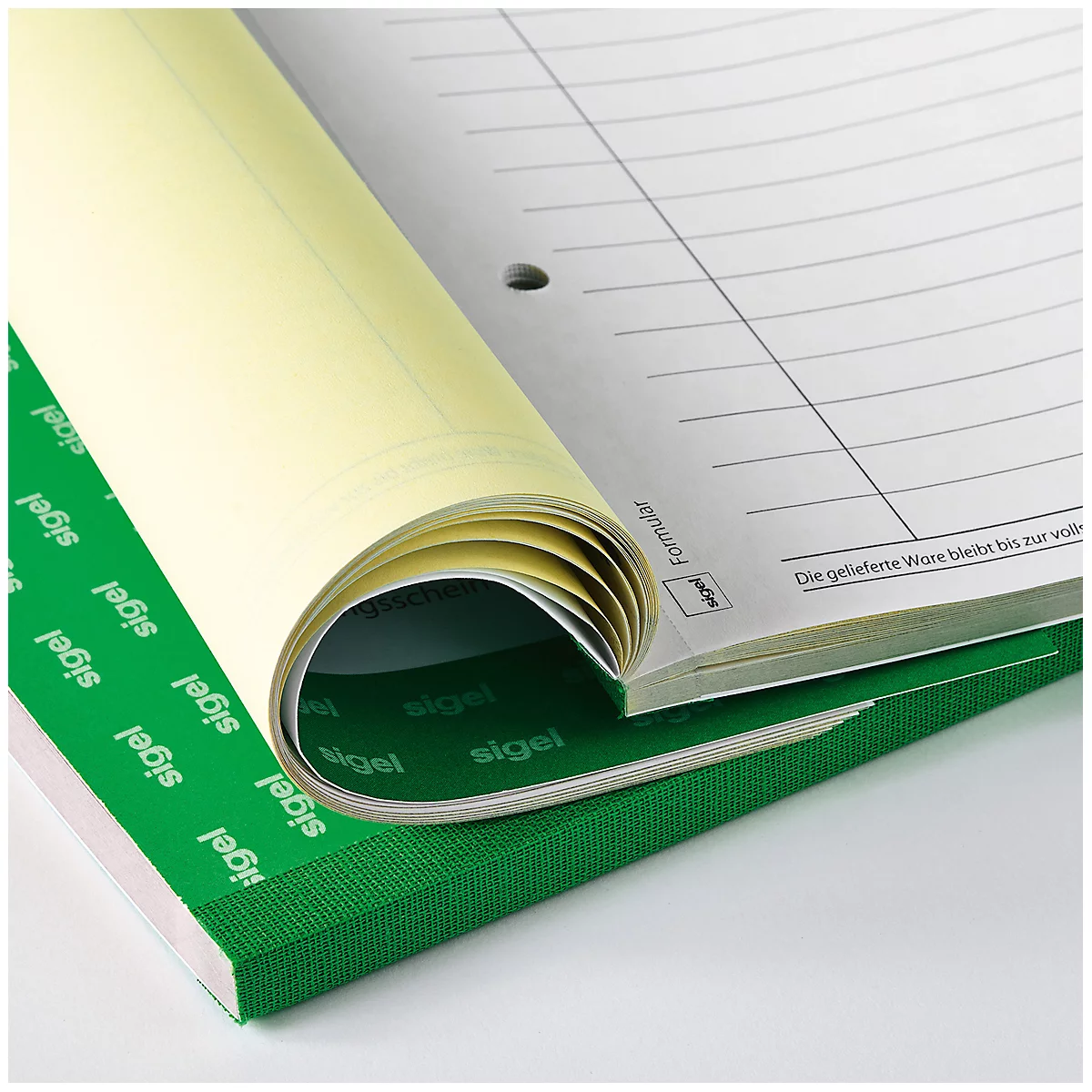 An open notebook with rolled-up pages. The green cover and light yellow pages stand out.