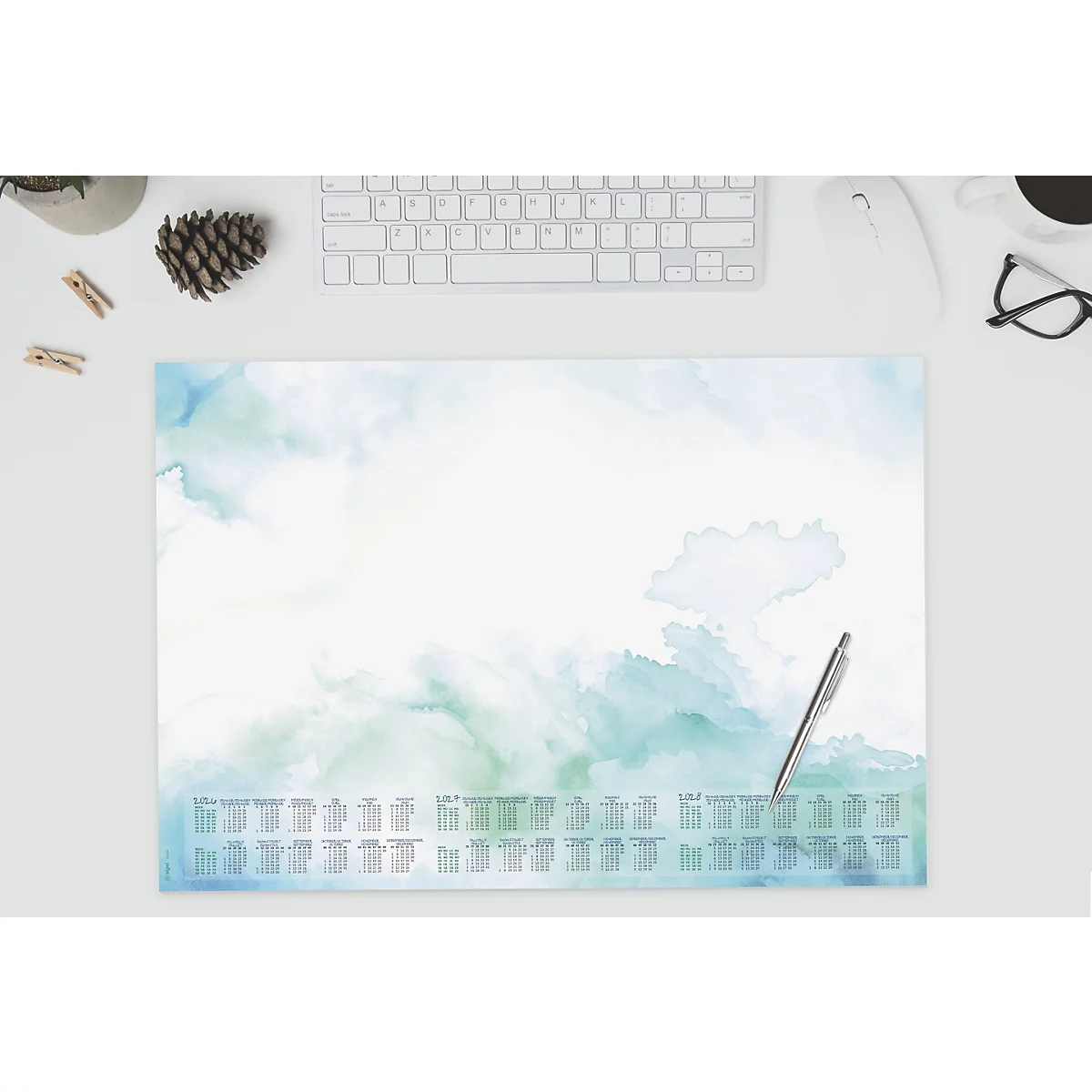 Schreibtischunterlage mit Kalender-Design, blau-grüne Aquarelloptik, Stift, Tastatur und Brille.