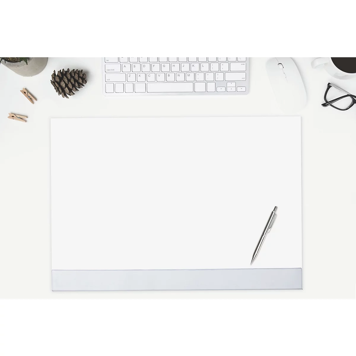 Draufsicht auf einen Schreibtisch mit Papier, Stift, Tastatur, Maus, Brille, Kaffee und Dekoration.