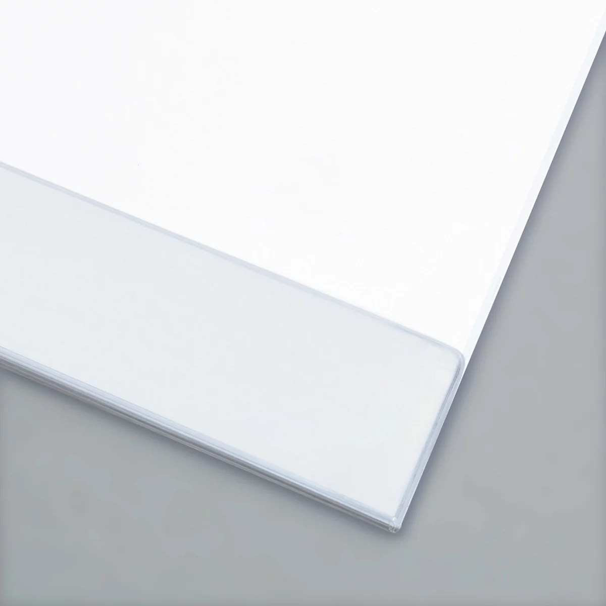 Nahaufnahme von weißem Papier auf grauem Grund. Das Papier ist gefaltet und zeigt Texturen.