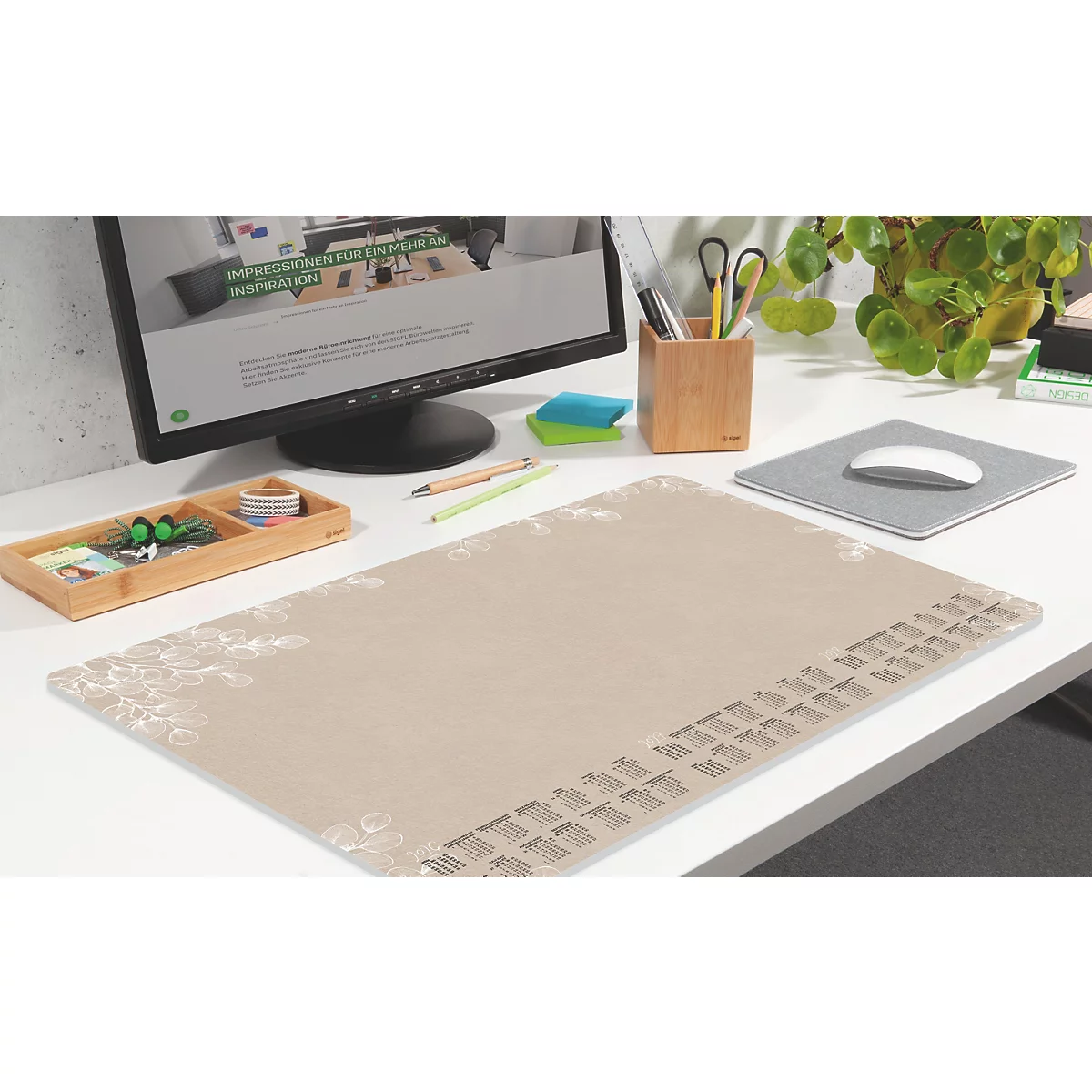 Tapis de bureau beige avec calendrier et détails floraux, avec souris, stylos, moniteur et plantes.