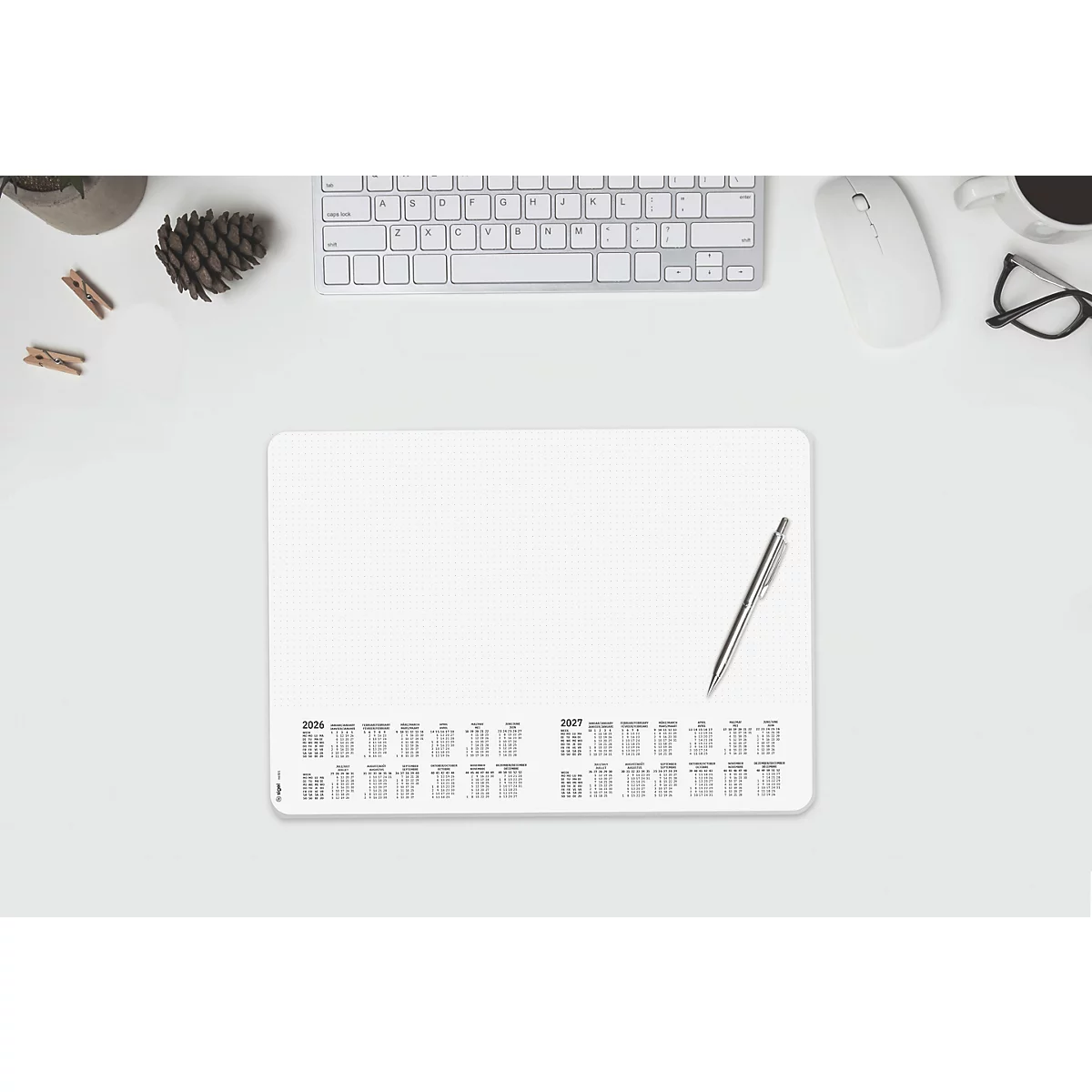 Configuration de bureau avec tapis de bureau blanc, stylo, clavier, souris et lunettes.