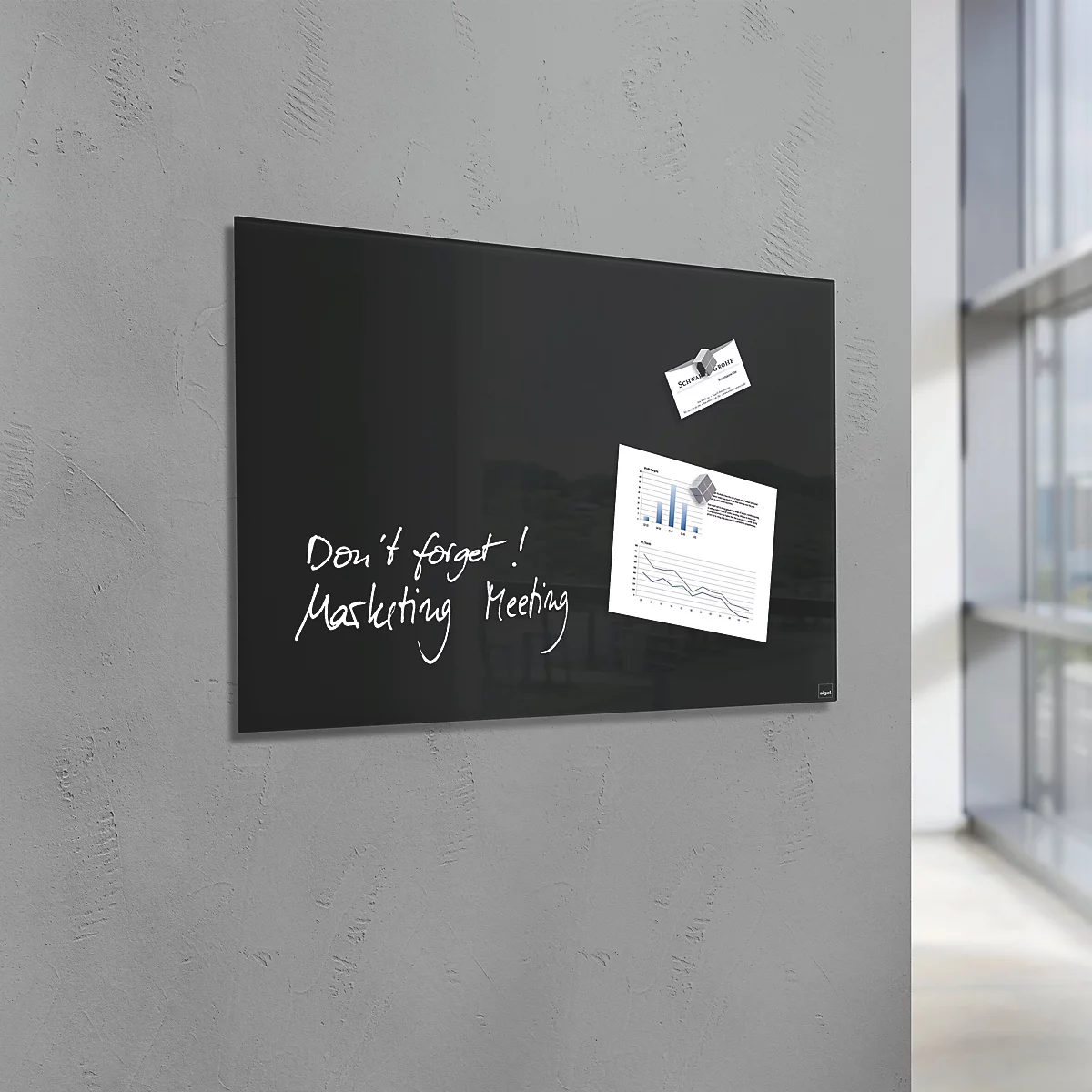 Tableau blanc noir avec des notes et des papiers attachés sur un mur gris.