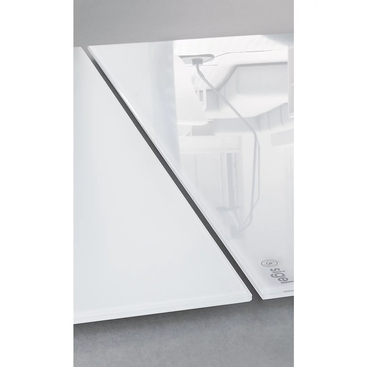 Gros plan d'une plaque de verre blanche avec un cadre noir. Des lettrages en gris sont visibles sur la plaque.