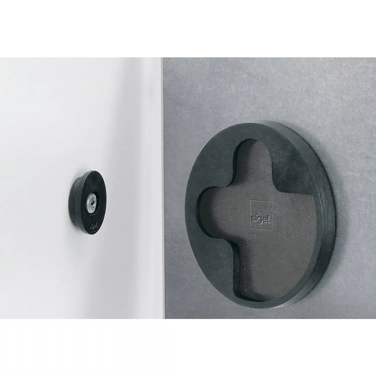 Deux objets noirs et ronds, l'un sur un mur blanc, l'autre sur un mur gris. L'objet sur le mur gris a une forme de croix.