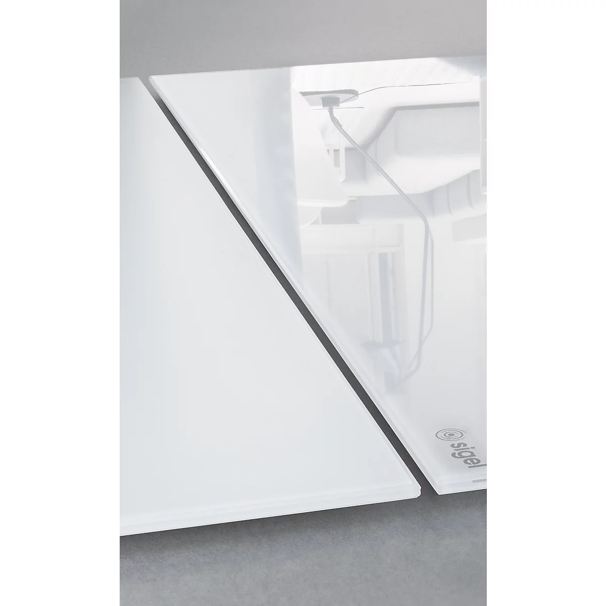 Gros plan d'une plaque de verre blanche, qui se trouve devant un fond gris.