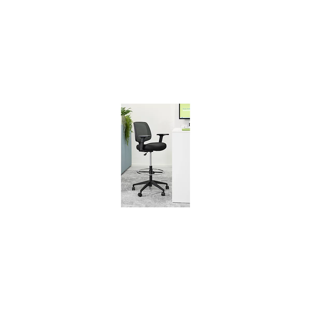 Silla de oficina negra con respaldo de malla, reposabrazos y reposapiés, sobre ruedas.
