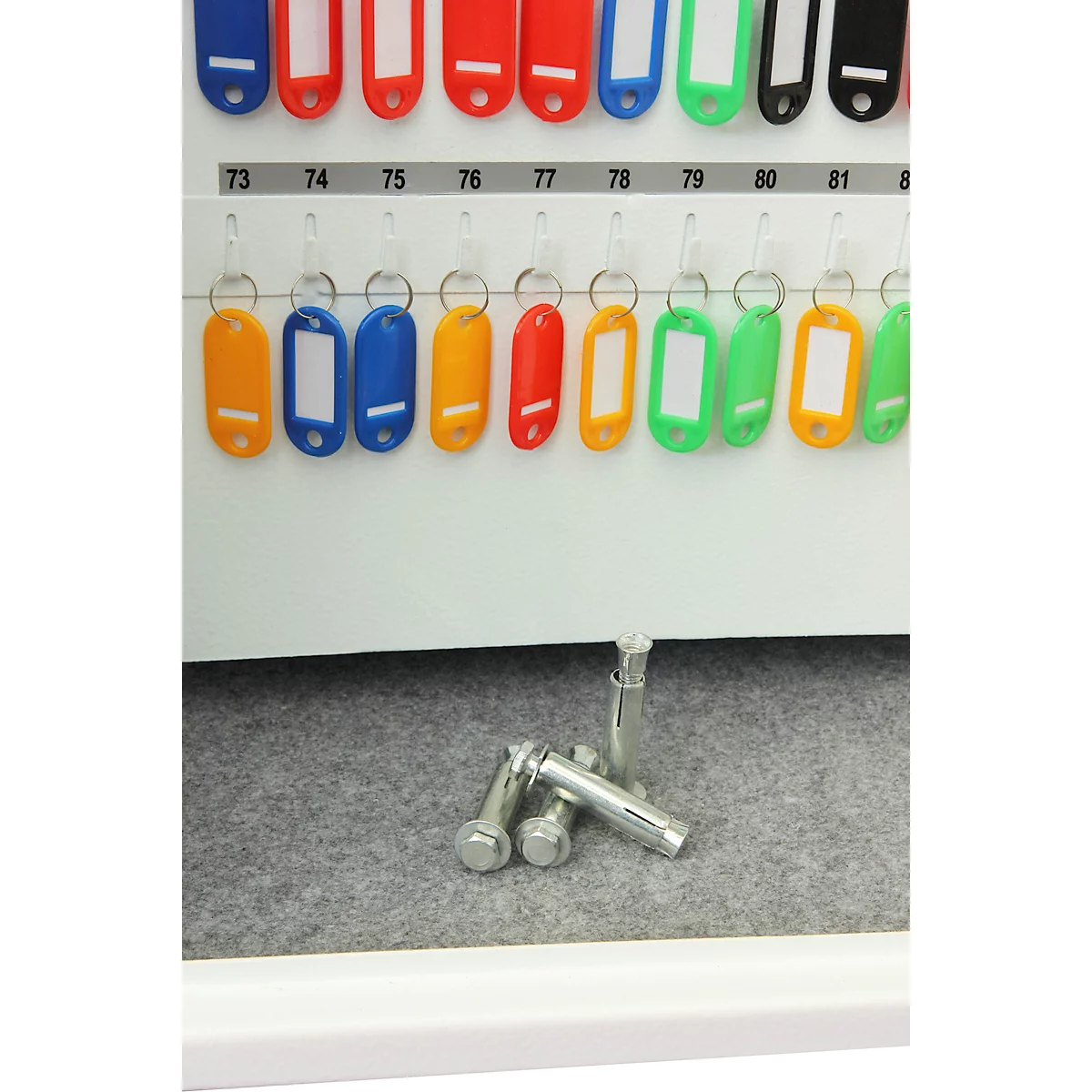 Sleutelrek met gekleurde sleutelhangers en genummerde rijen. Schroeven liggen eronder.
