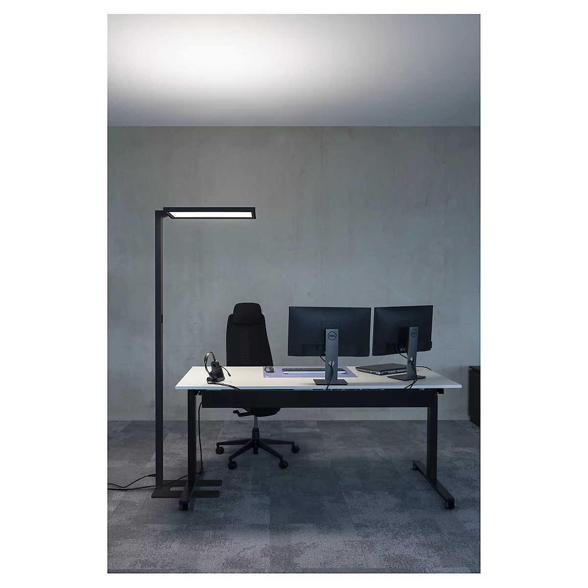 Schreibtisch mit zwei Monitoren, Bürostuhl, Stehlampe mit LED-Leuchte.