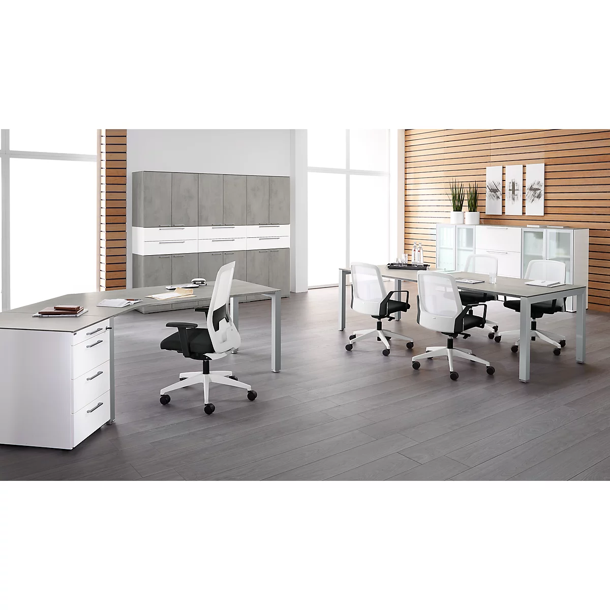 Office with desks, chairs and cabinets. Light wood paneling, gray floor. Windows letting in light.