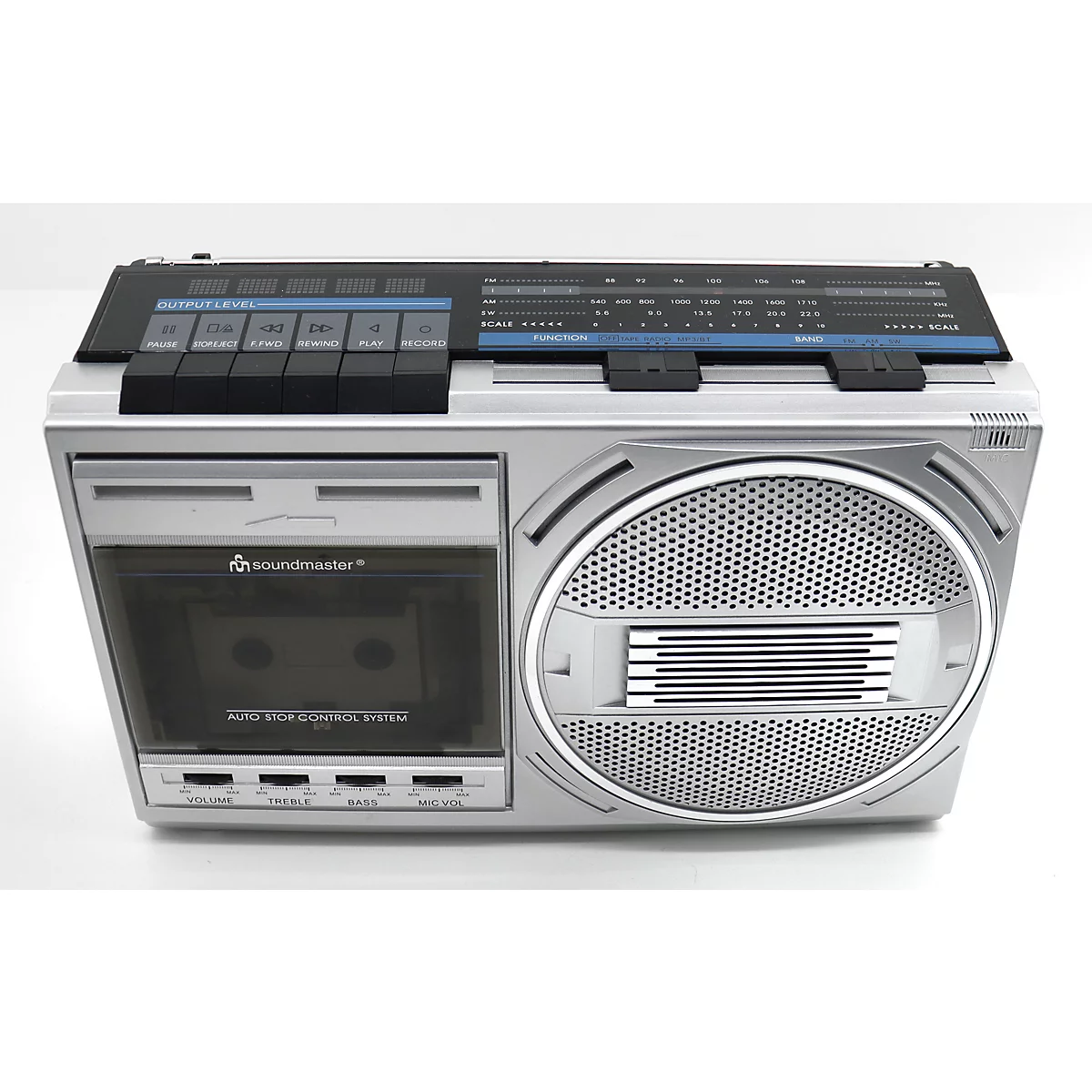Boombox argenté sur fond blanc, avec un lecteur de cassettes et un haut-parleur.