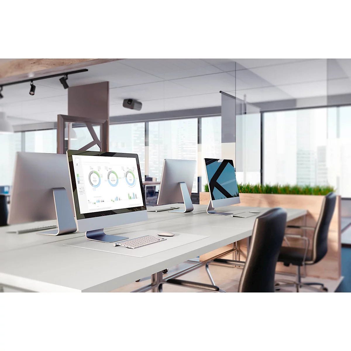 Bureau avec des ordinateurs sur un bureau. Des graphiques sont visibles sur l'écran.