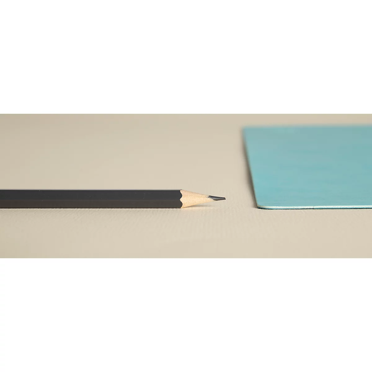 Un crayon noir à pointe aiguisée est posé à côté d'un rectangle turquoise sur un fond clair.