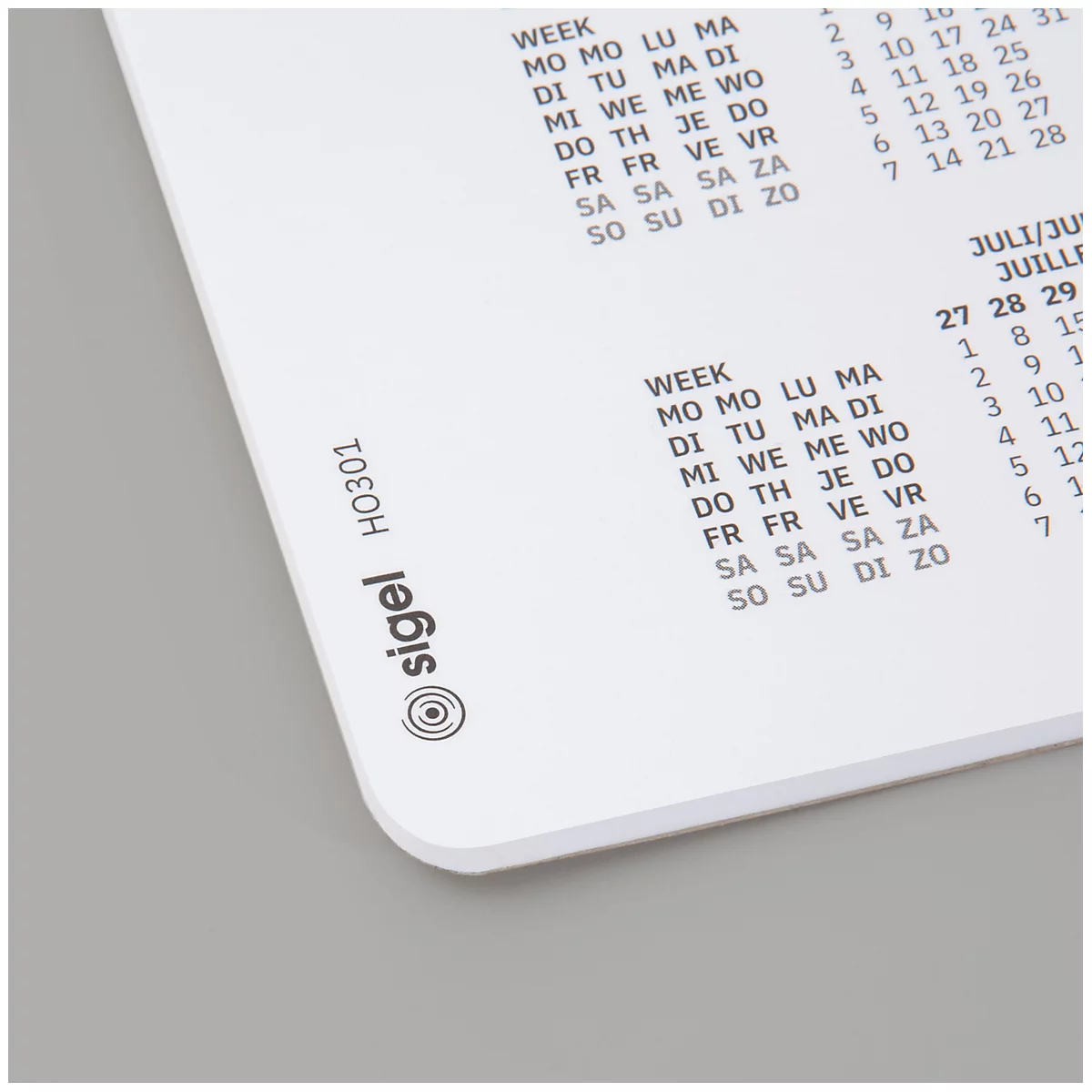 Gros plan sur un calendrier blanc avec les désignations des semaines et les noms des mois, ainsi que le logo de la société Sigel.